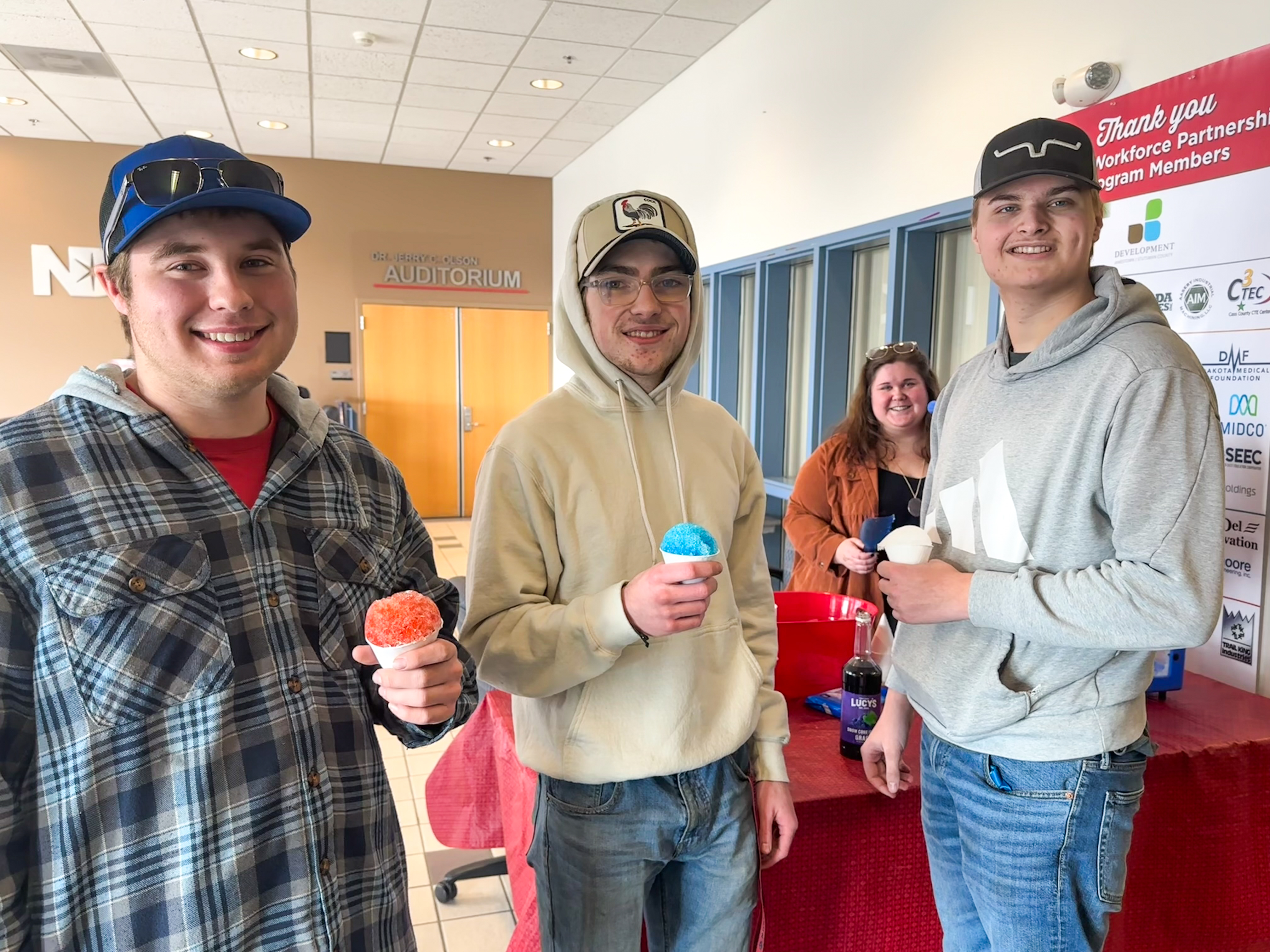 3 students standing holding snow cones.