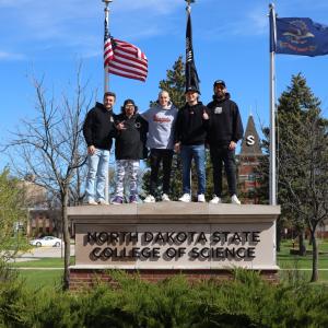 CboysTV group standing on top of NDSCS sign