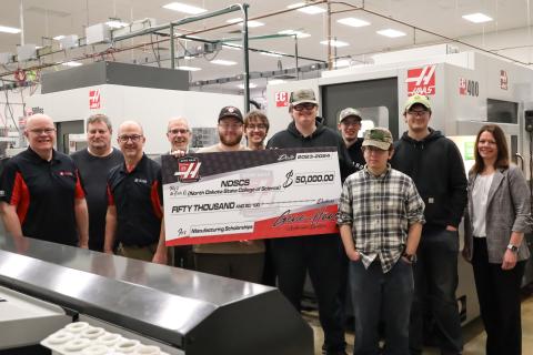 full group of students and faculty receiving giant check