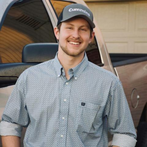 Man wearing a baseball cap standing next to a pickup window