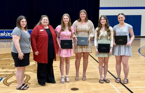 group of students standing together holding diplomas