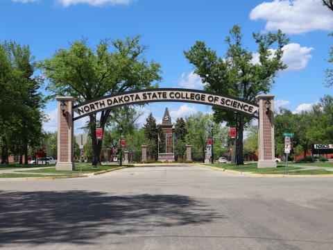 NDSCS archway with historic Old Main building steeple in background